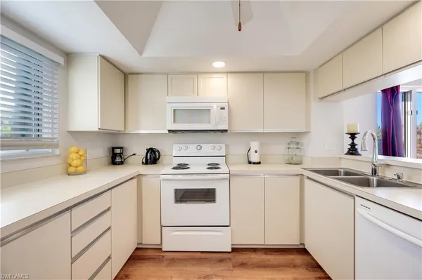 a kitchen with sink a microwave and cabinets