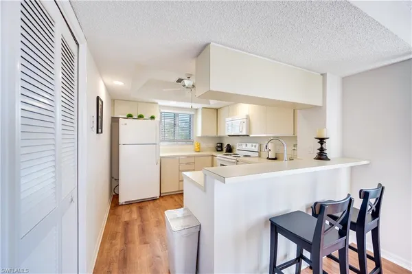 a kitchen with white cabinets and refrigerator