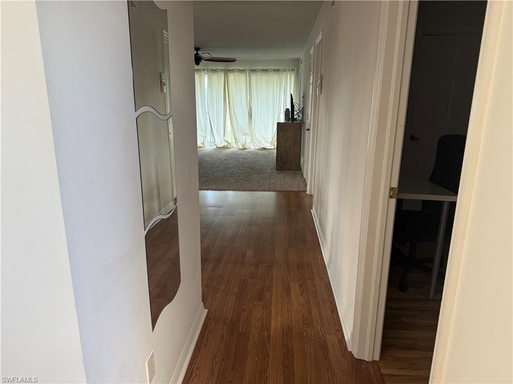 1645 Spoonbill Lane, Unit C Naples, FL 34105 - Photo 22 of 50 Corridor with baseboards and dark wood-style floors
