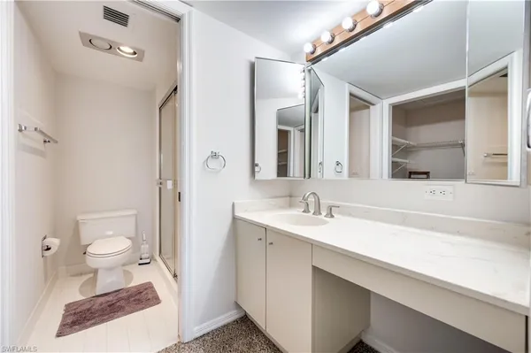 a bathroom with a sink toilet a mirror and shower