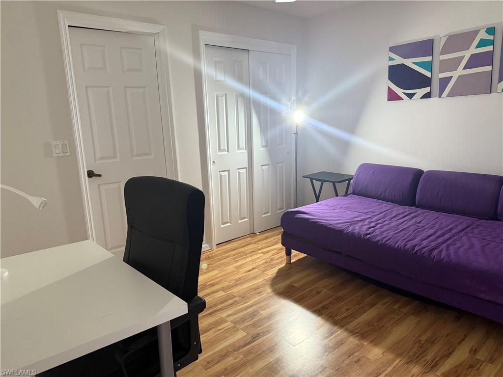 1645 Spoonbill Lane, Unit C Naples, FL 34105 - Photo 27 of 50 Bedroom featuring light wood finished floors, a closet, and a desk