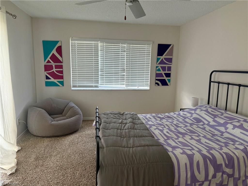 1645 Spoonbill Lane, Unit C Naples, FL 34105 - Photo 29 of 50 Bedroom with a textured ceiling, carpet flooring, and ceiling fan