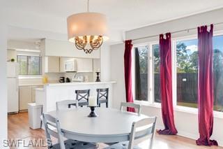 1645 Spoonbill Lane, Unit C Naples, FL 34105 - Photo 7 of 50 Dining area with light wood finished floors and a chandelier