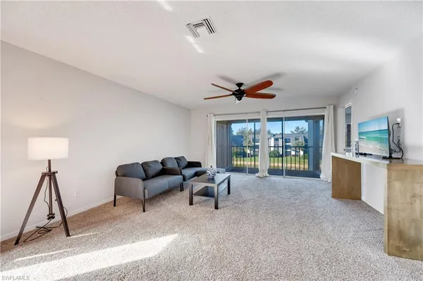 a living room with furniture a window and a flat screen tv