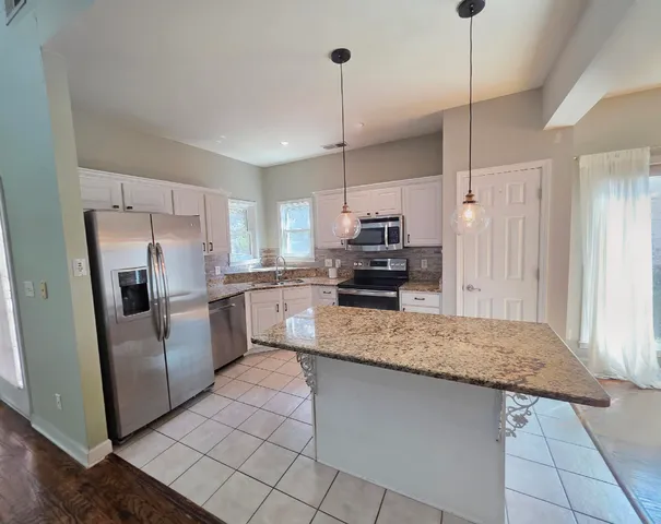 a kitchen with stainless steel appliances granite countertop a refrigerator a sink and a stove