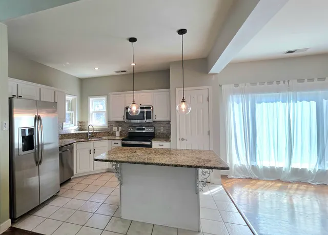 a kitchen with stainless steel appliances granite countertop a stove a sink and a refrigerator