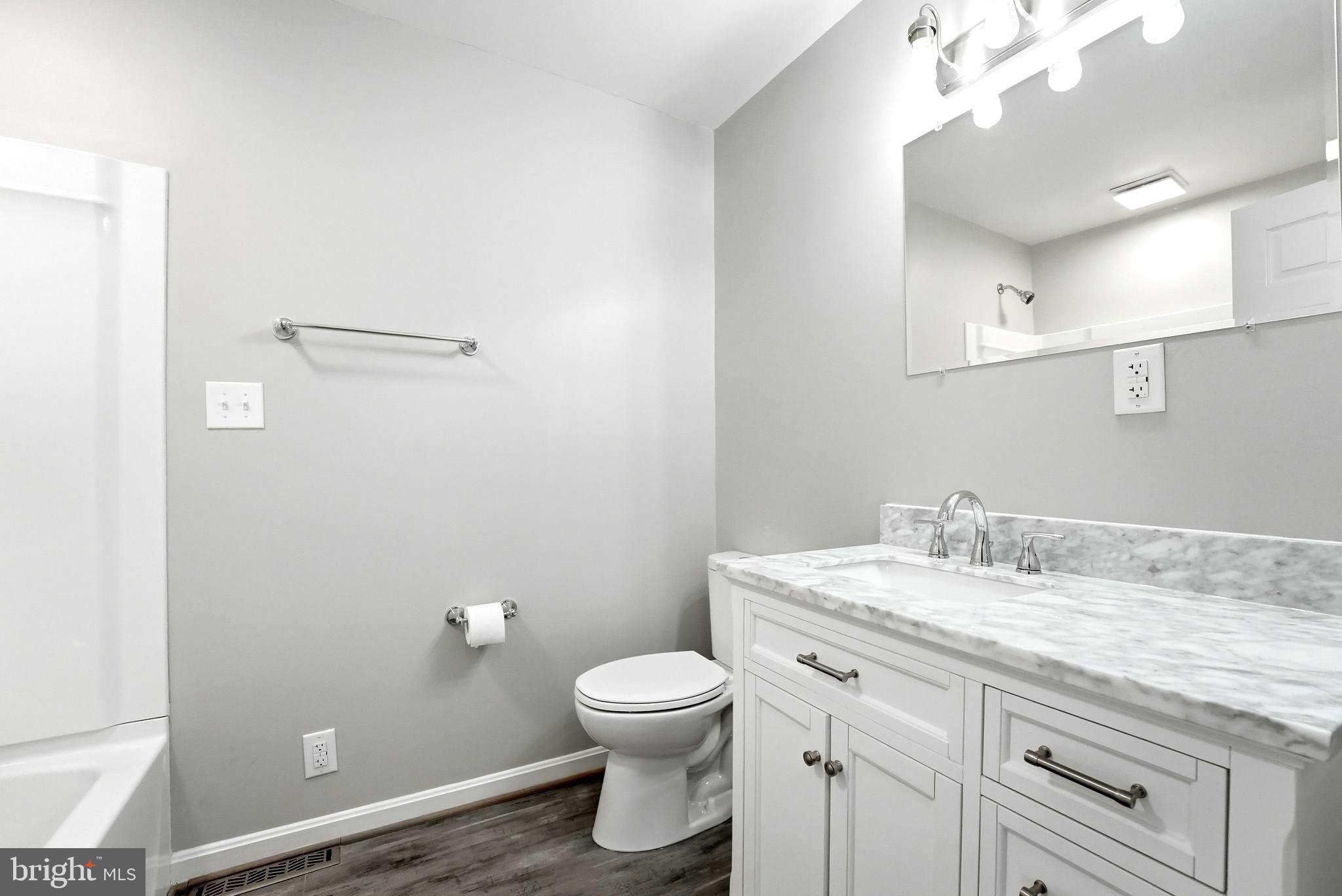 22064 Yellow Bottom Road Lignum, VA 22726 - Photo 20 of 50 a bathroom with a granite countertop toilet a sink and a mirror