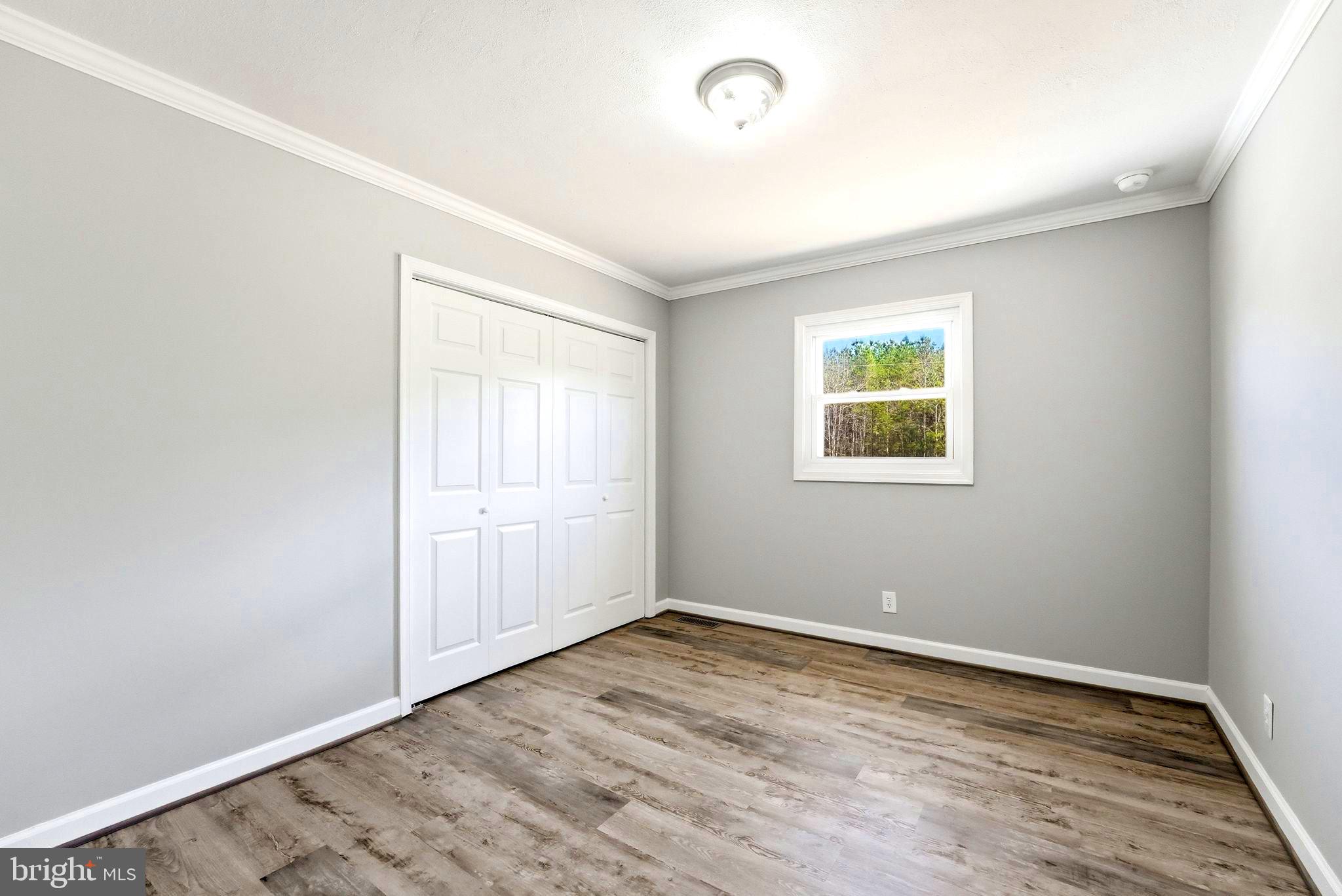 22064 Yellow Bottom Road Lignum, VA 22726 - Photo 22 of 50 an empty room with wooden floor and windows