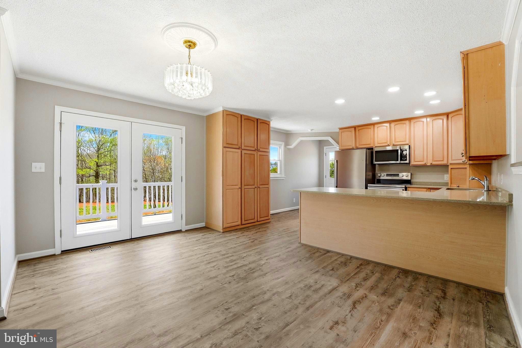 22064 Yellow Bottom Road Lignum, VA 22726 - Photo 5 of 50 a living room with stainless steel appliances kitchen island granite countertop a refrigerator a stove a oven with a dining table and chairs with wooden floor