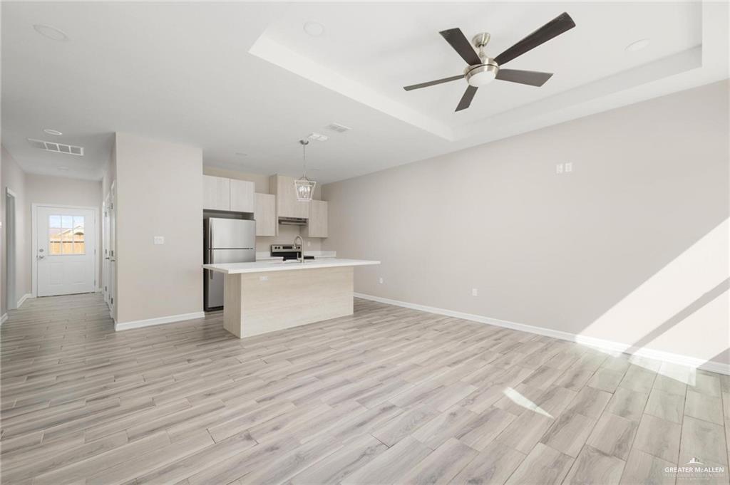 415 East 3rd Street La Joya, TX 78560 - Photo 2 of 11 a view of a kitchen with wooden floor and a ceiling fan
