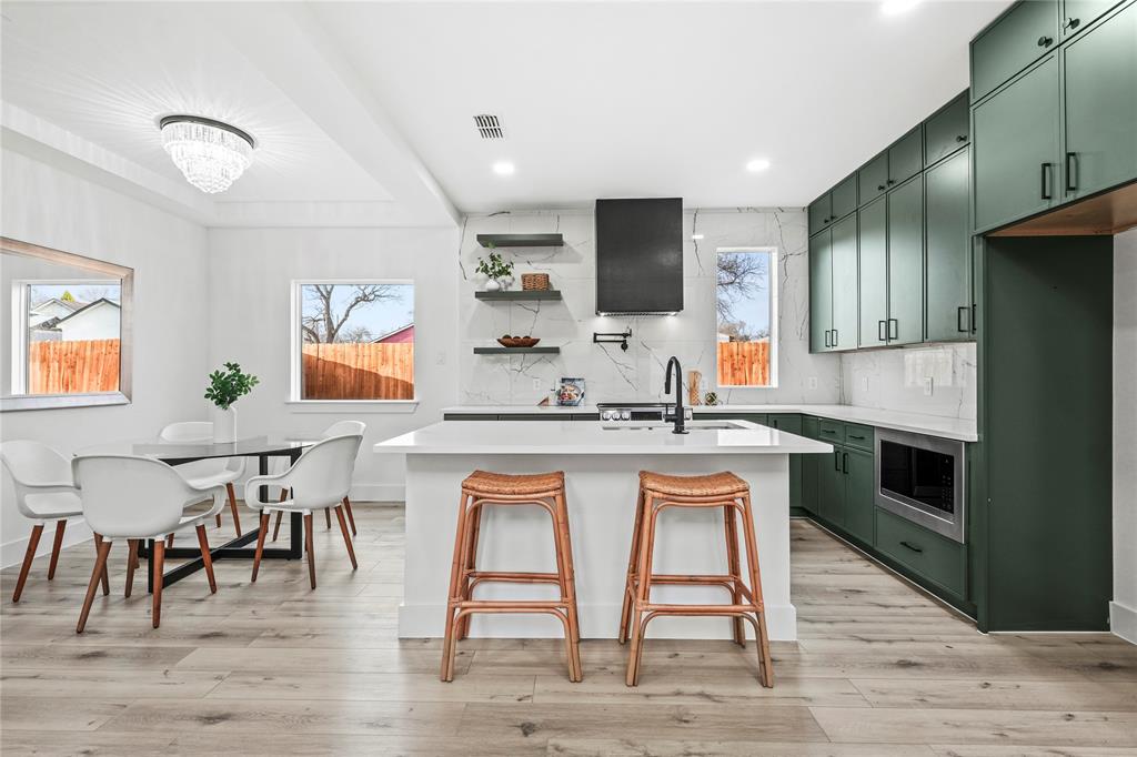4712 Garrison Street Dallas, TX 75216 - Photo 13 of 30 Kitchen featuring green cabinetry, decorative backsplash, a center island with sink, healthy amount of natural light, and recessed lighting