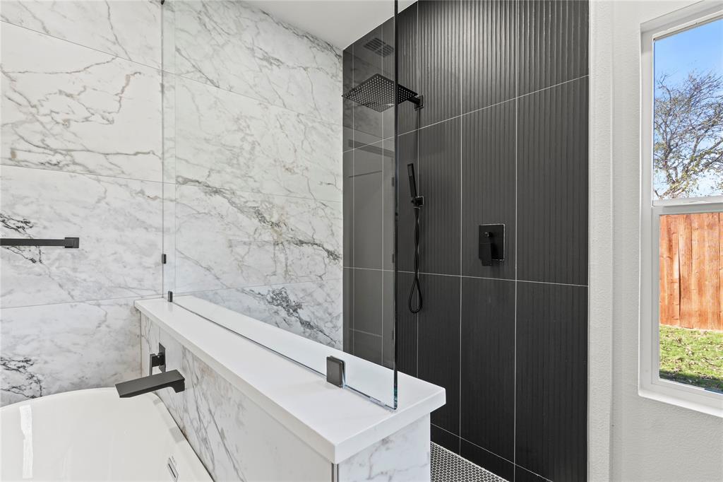 4712 Garrison Street Dallas, TX 75216 - Photo 18 of 30 Bathroom with walk in shower, a freestanding bath, and tile walls