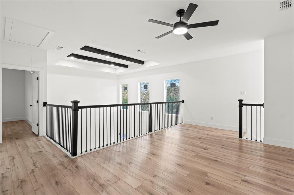 4712 Garrison Street Dallas, TX 75216 - Photo 21 of 30 Spare room featuring attic access, a raised ceiling, light wood-style floors, and ceiling fan