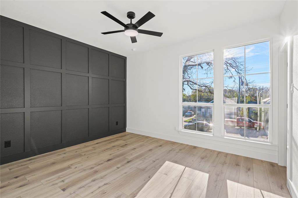 4712 Garrison Street Dallas, TX 75216 - Photo 22 of 30 Unfurnished bedroom featuring a decorative wall, light wood finished floors, and ceiling fan