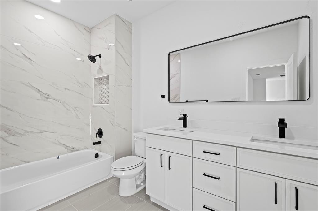4712 Garrison Street Dallas, TX 75216 - Photo 23 of 30 Full bathroom with bathtub / shower combination, double vanity, light tile patterned flooring, and recessed lighting
