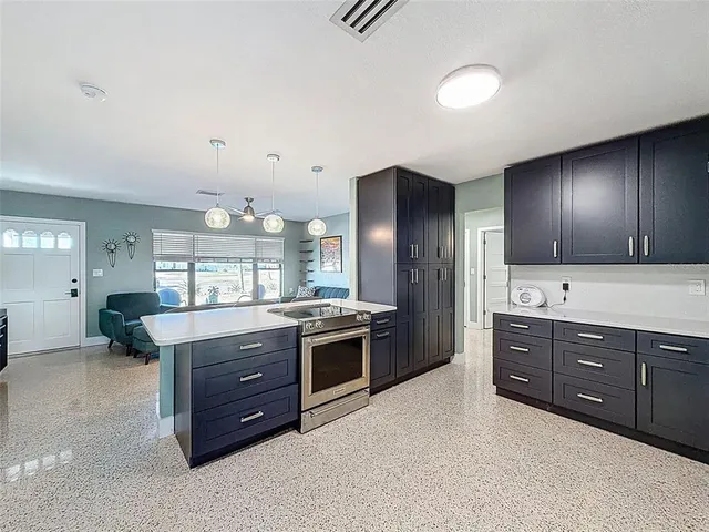 a large kitchen with stainless steel appliances granite countertop a stove and a sink