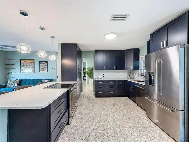 a large kitchen with a refrigerator a sink a stove and microwave