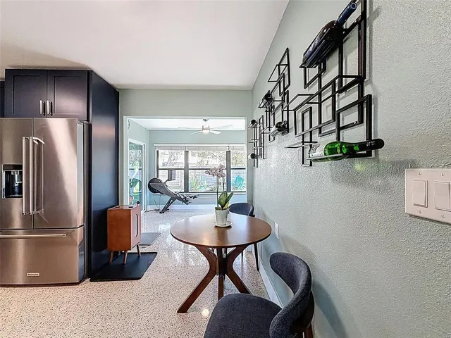 a kitchen with stainless steel appliances a table chairs and a refrigerator