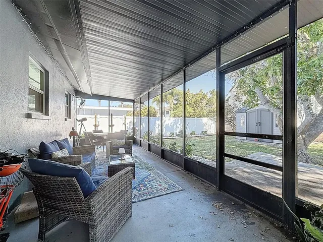 a living room with furniture floor to ceiling windows and a table