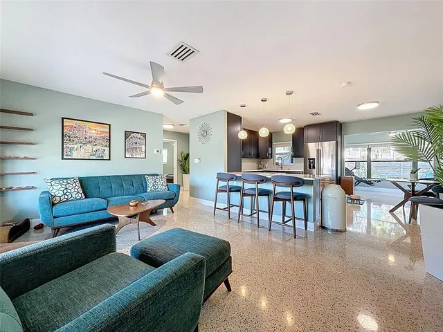 a living room with furniture and a view of kitchen