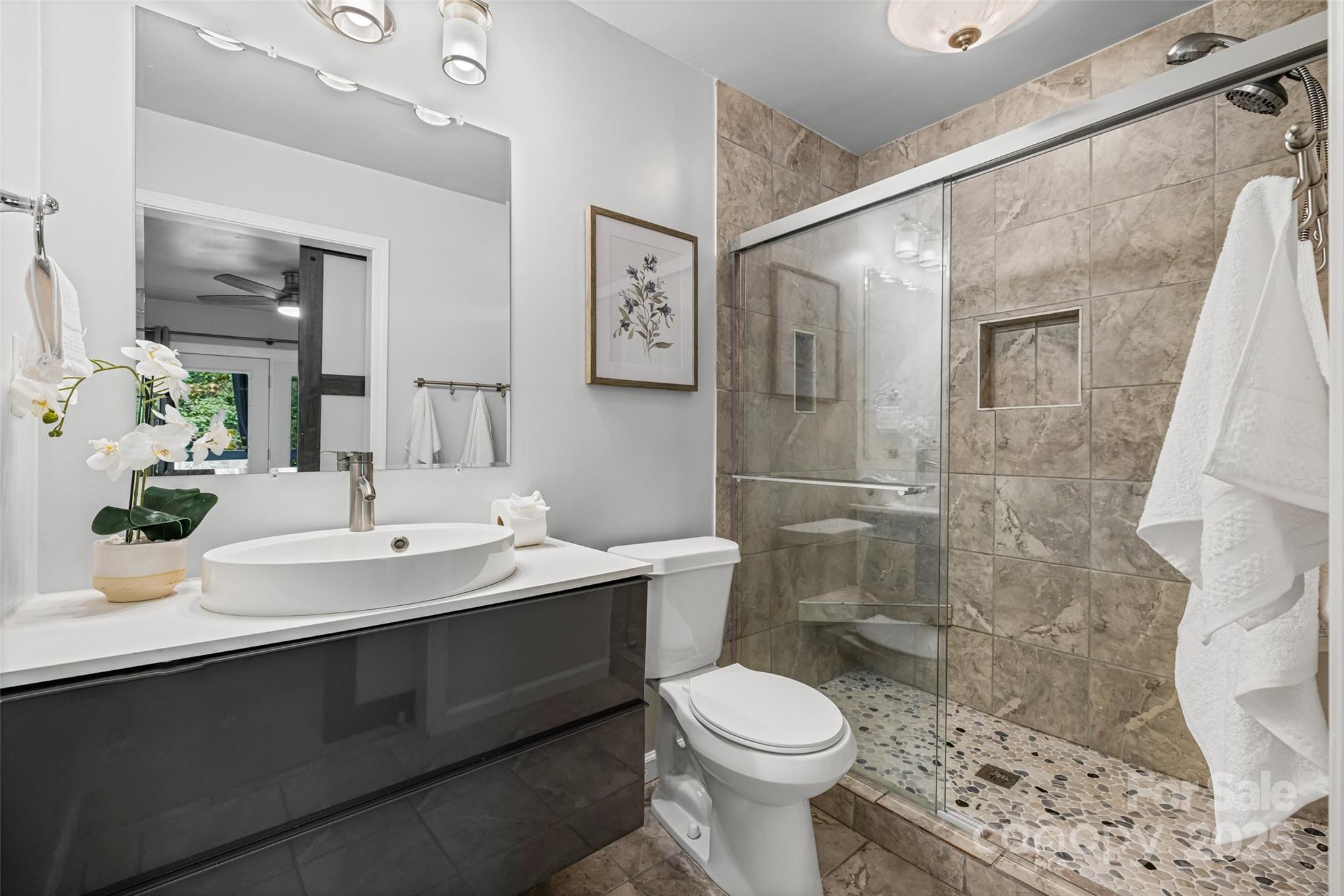 6027 Windjammer Drive Tega Cay, SC 29708 - Photo 22 of 34 a bathroom with a sink a toilet and shower