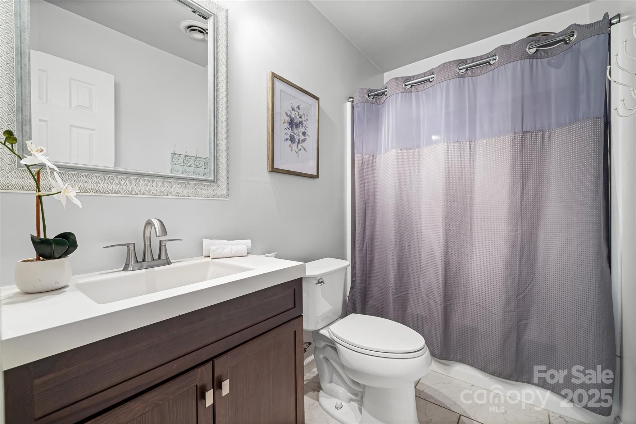 6027 Windjammer Drive Tega Cay, SC 29708 - Photo 25 of 34 a bathroom with a sink a toilet and shower