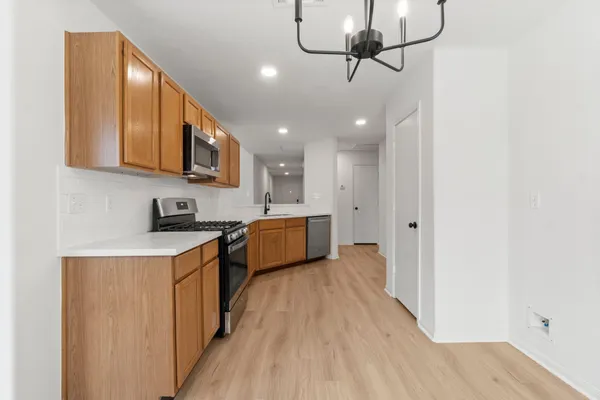 a kitchen with stainless steel appliances granite countertop a sink cabinets and wooden floor