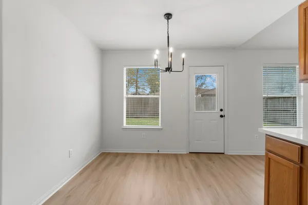 a view of empty room with wooden floor and window