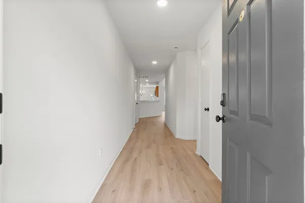a view of a hallway with wooden floor