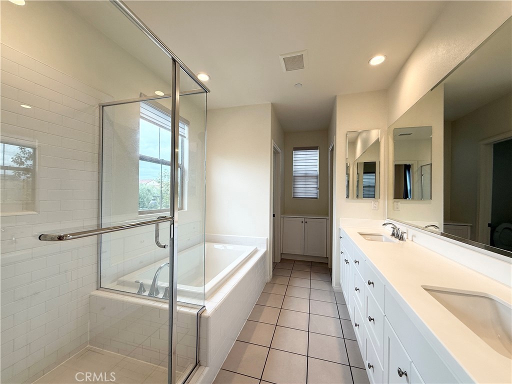 126 Okra Irvine, CA 92618 - Photo 15 of 26 a spacious bathroom with a tub sink shower and mirror