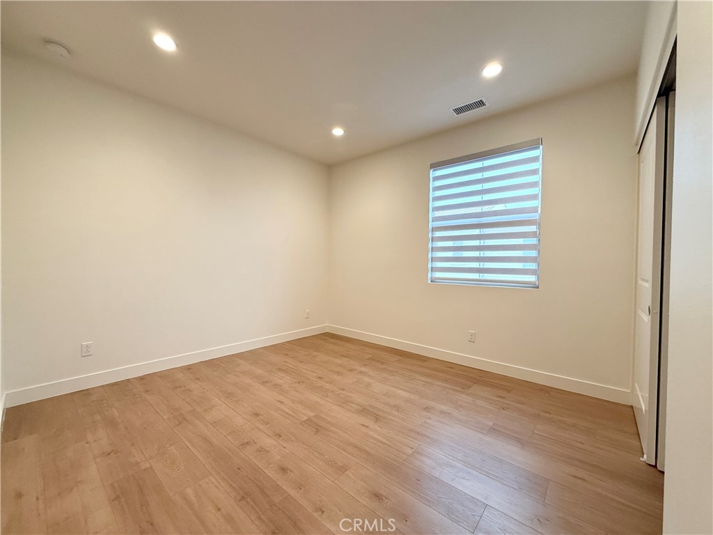 126 Okra Irvine, CA 92618 - Photo 20 of 26 an empty room with wooden floor and windows
