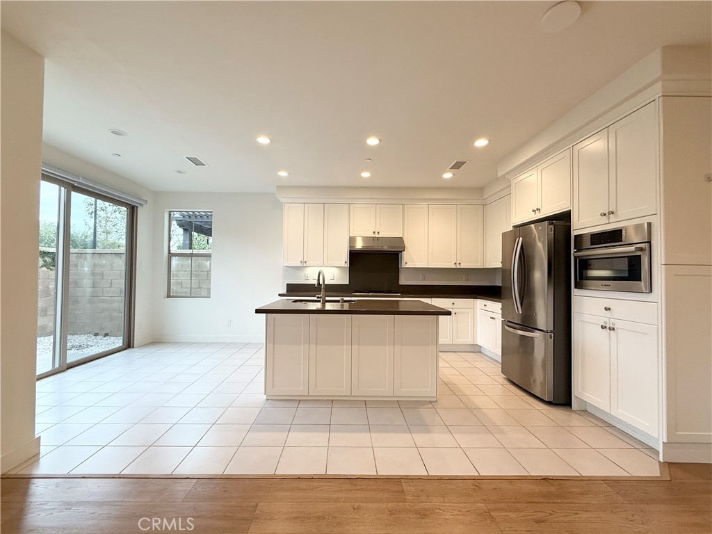 126 Okra Irvine, CA 92618 - Photo 6 of 26 a large kitchen with a large counter top stainless steel appliances and cabinets