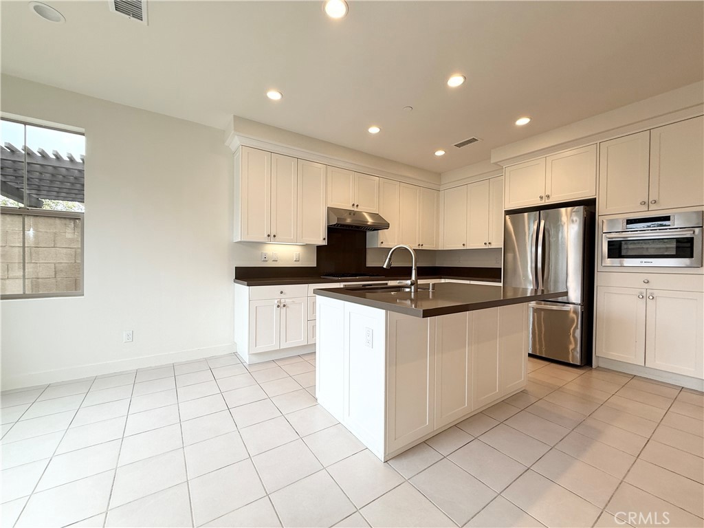 126 Okra Irvine, CA 92618 - Photo 7 of 26 a kitchen with stainless steel appliances granite countertop a refrigerator sink and cabinets
