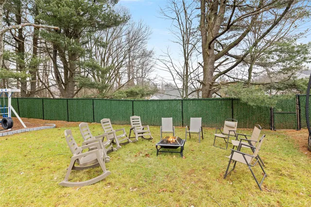 a view of backyard with table and chairs and wooden fence