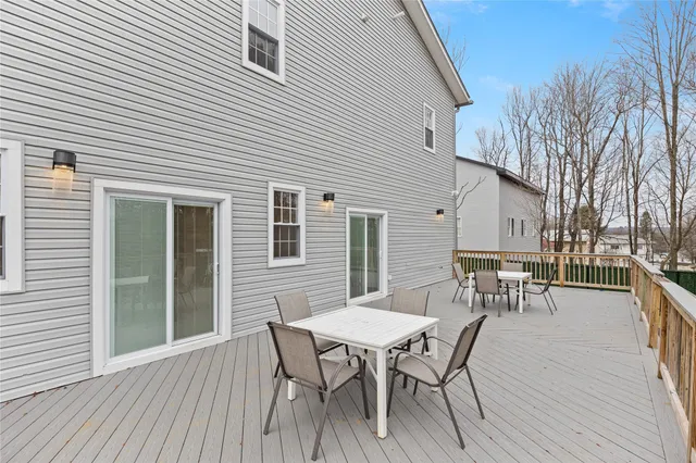 a view of a roof deck with table and chairs and wooden floor