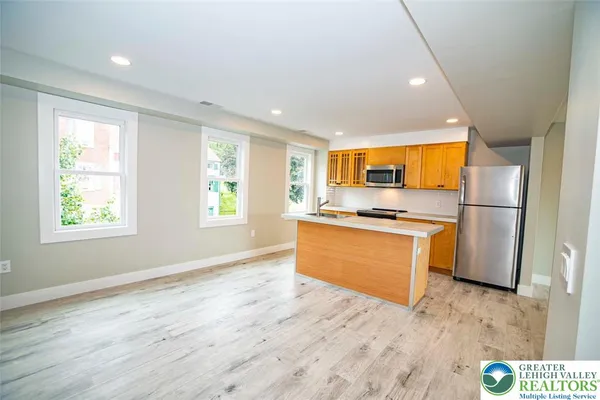 a kitchen with stainless steel appliances granite countertop a stove a sink and a refrigerator