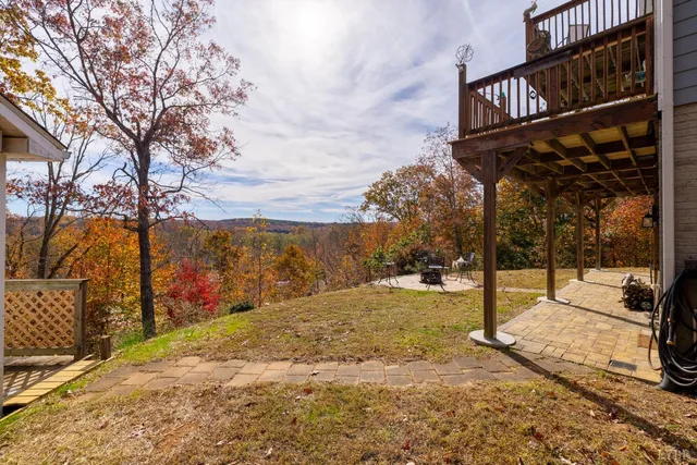 a front view of a house with a yard and mountain view in back