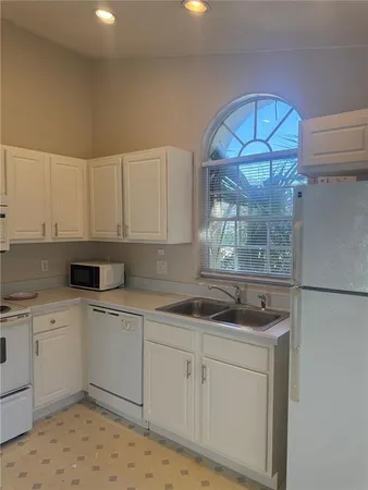 a kitchen with a sink cabinets and window