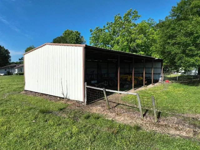 a view of backyard with wooden fence and a large tree