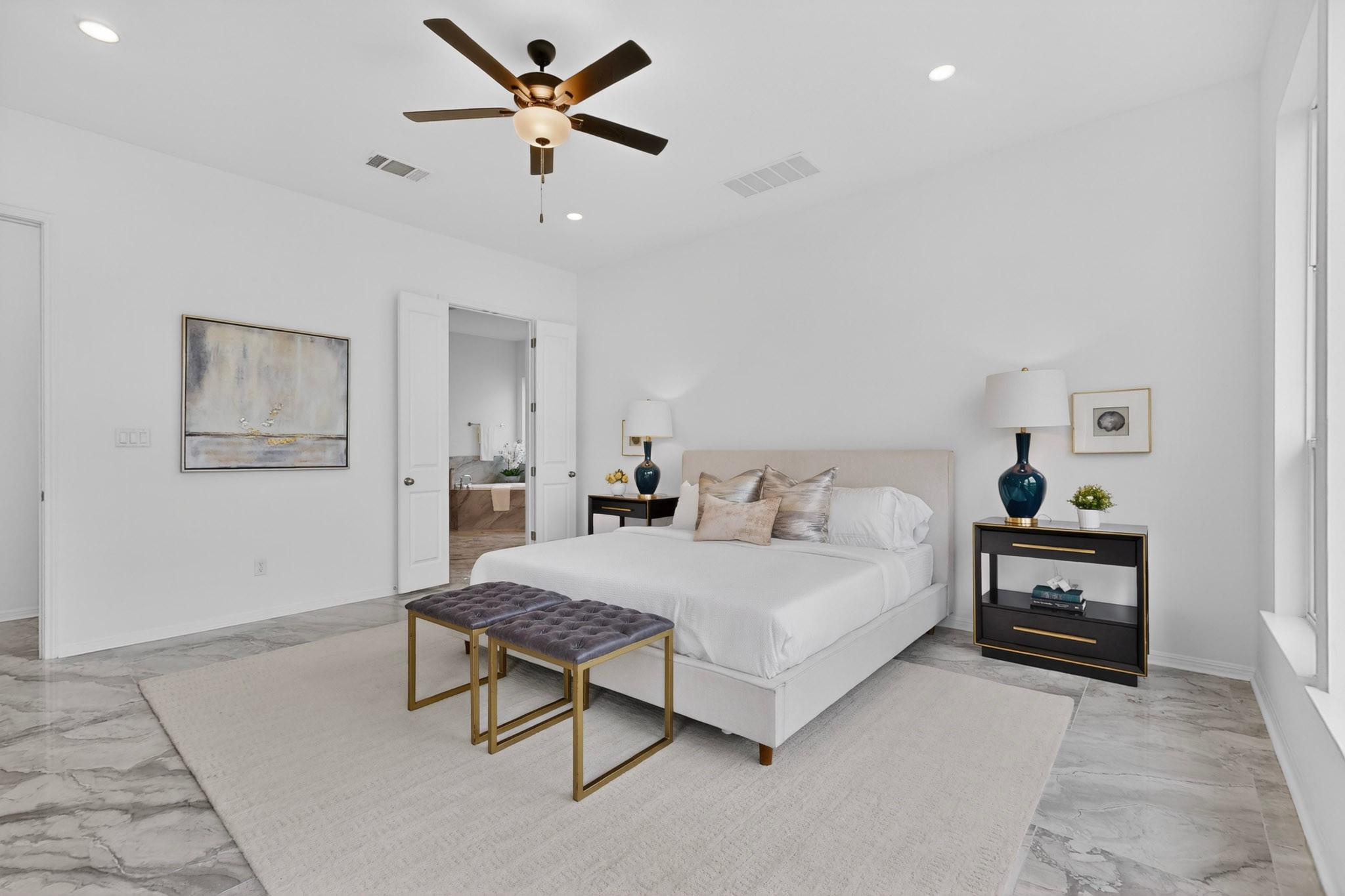 2308 Mondello Path Leander, TX 78641 - Photo 12 of 39 A tranquil primary bedroom with a cooling ceiling fan features durable tile flooring, providing a calm retreat.