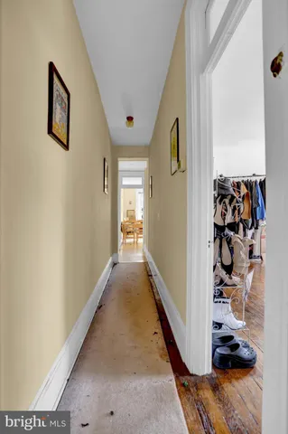 a view of a hallway with wooden floor and closet