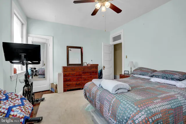 a bedroom with a bed and a flat tv screen on dresser
