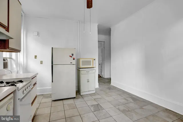 a kitchen with a refrigerator a stove top oven and cabinets