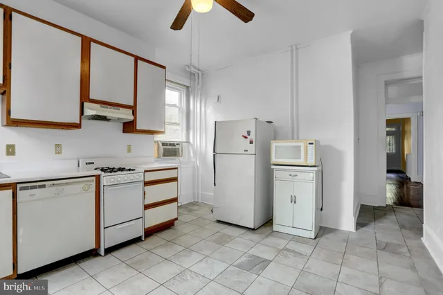 a kitchen with white cabinets and white appliances