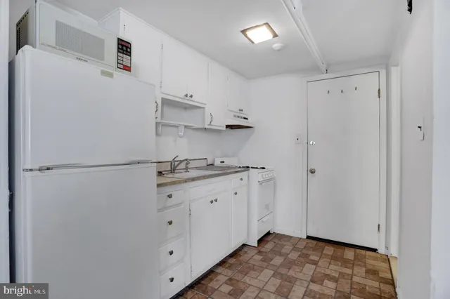 a kitchen with white cabinets and white appliances
