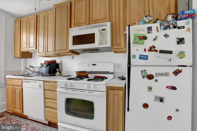a kitchen with cabinets appliances and wooden floor