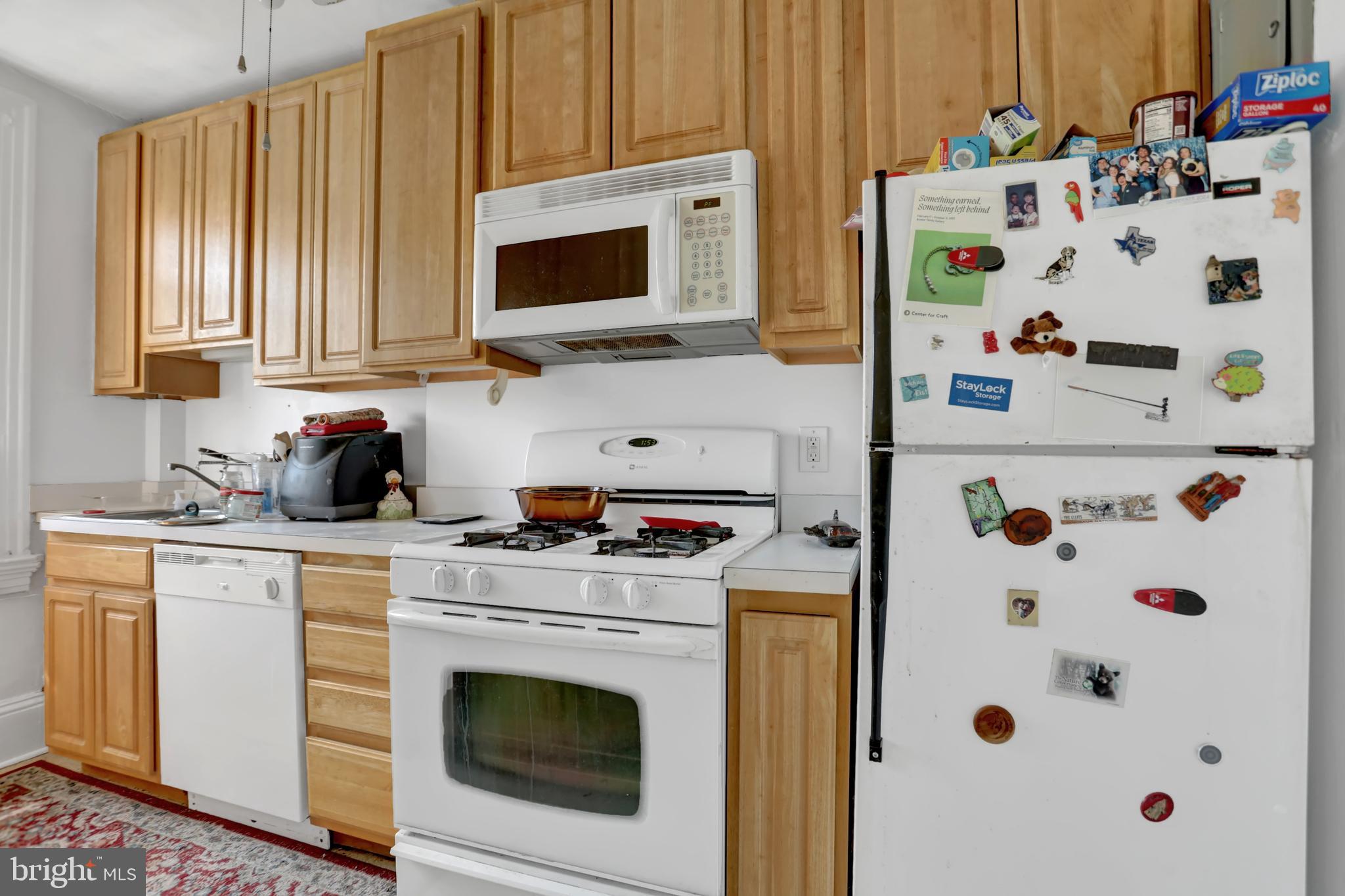 3001 North Calvert Street Baltimore, MD 21218 - Photo 9 of 44 a kitchen with cabinets appliances and wooden floor