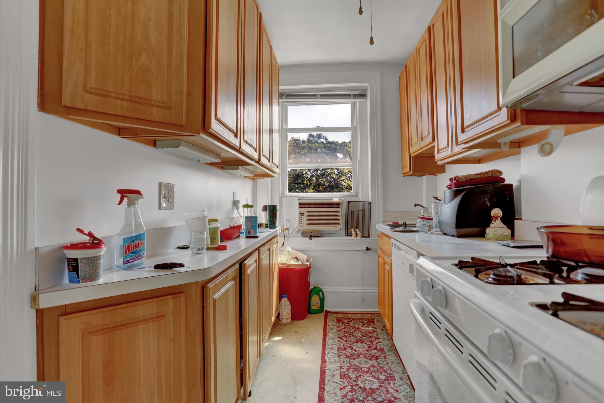 3001 North Calvert Street Baltimore, MD 21218 - Photo 10 of 44 a kitchen with a stove and wooden cabinets