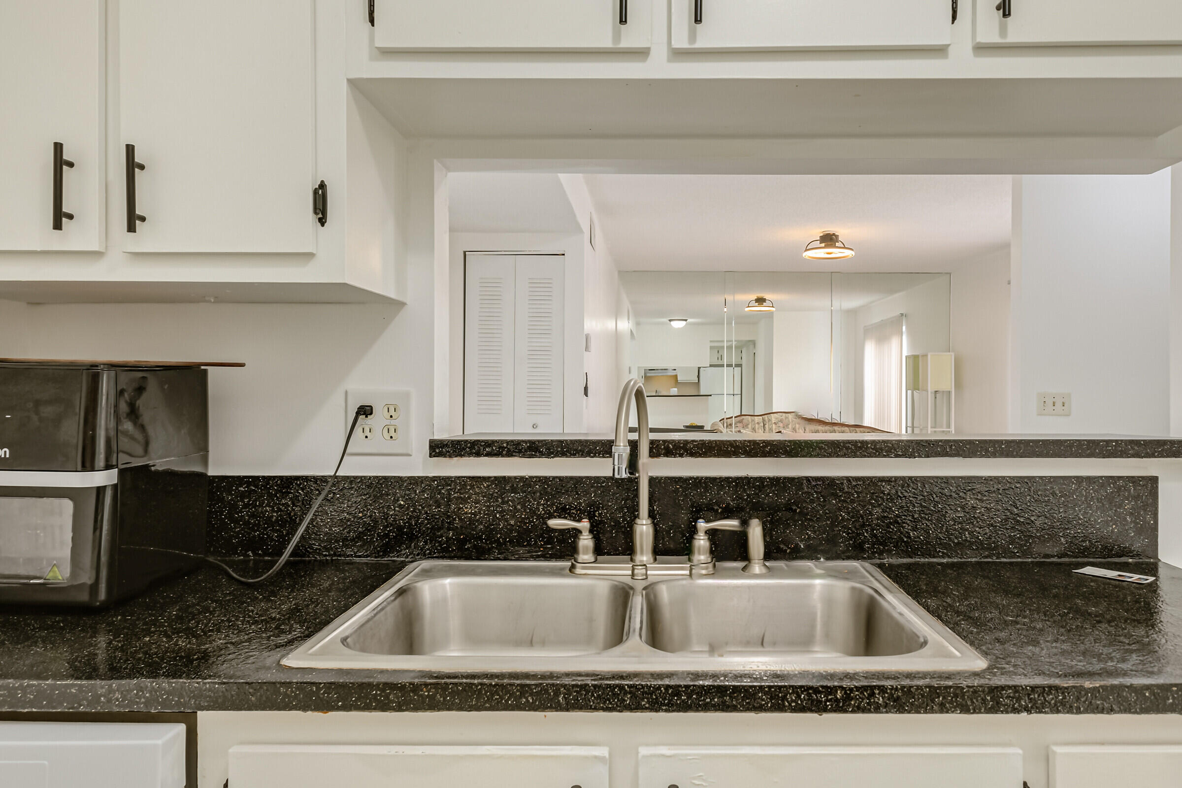 720 Ridge Club Drive, Unit 43 Melbourne, FL 32934 - Photo 3 of 27 a kitchen sink with granite countertop white cabinets and a sink