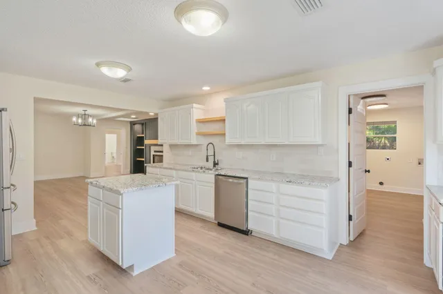 a kitchen with granite countertop white cabinets and white appliances